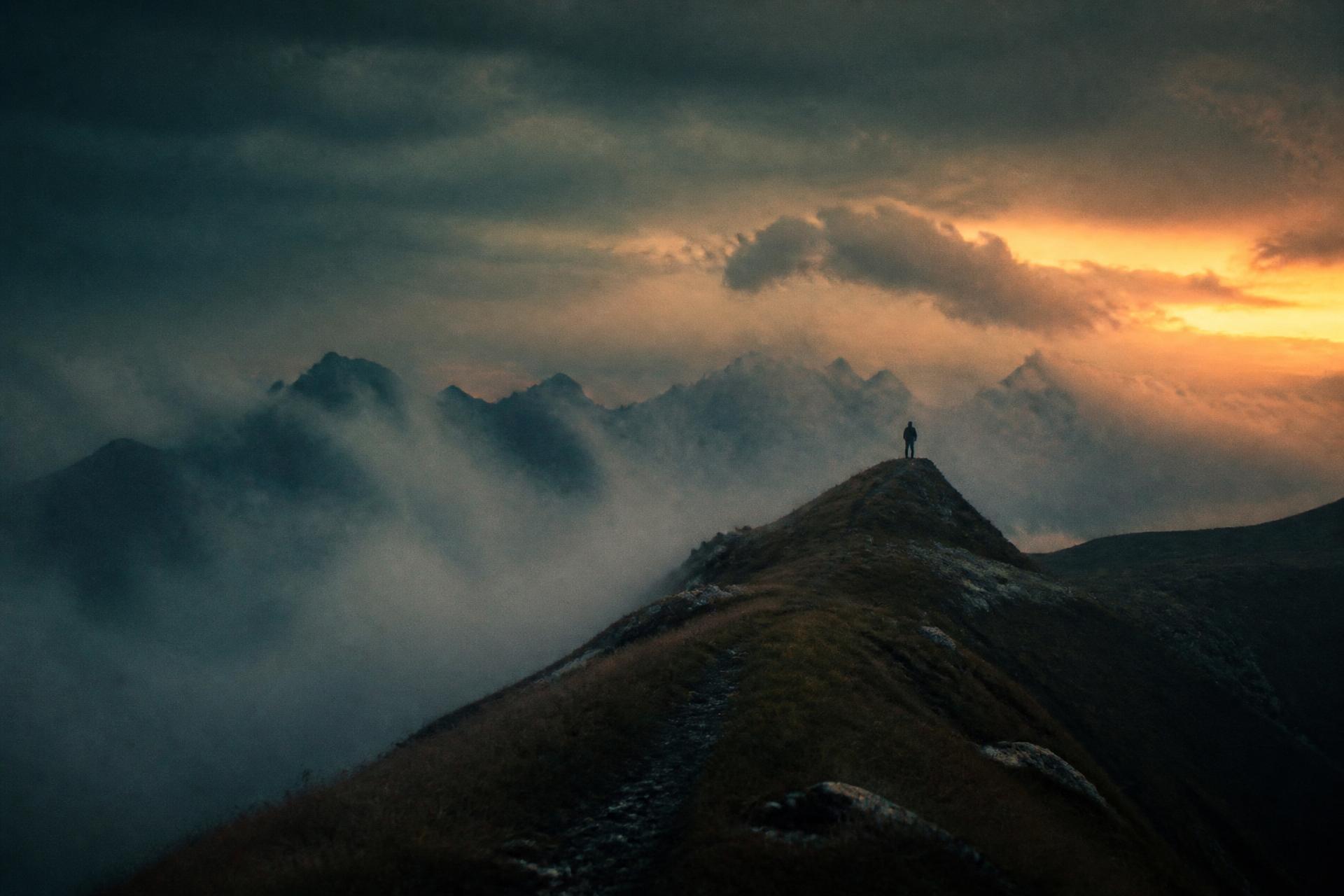 Photographer on a mountain ridge at dusk, graded with LUMORA presets